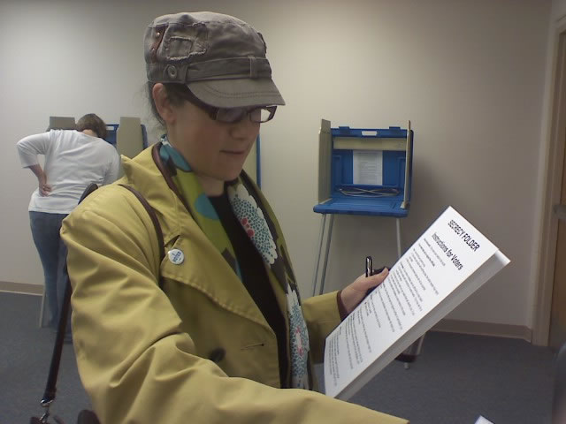 julia-neff-voting My voting place in North Liberty, Johnson County, Iowa (pop. 10,000) opened at 7am. When I arrived at 7:02 the parking lot was full and about 100 people were already in line. I was done voting by 7:45, but the other of the two precincts in town is much larger, so those folks were probably there for another 30-60 minutes. I got some great photos of the people working there. They were wonderful! The woman behind me in line had a 5 year old son who kept asking why they had to wait so long. The mother said, "Because this is very important." I agree! I had a smooth and enjoyable voting experience! -- Julia Neff.