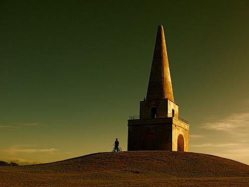 2977900527_ab439e2bf0 Shot with my Canon G7. Colour enhancement with iPhoto. I've seen the Obelisk on Killiney Hill a million times. Man and boy. Today I saw it differently. It looked as crisp and clean as the Artic wind blowing relentless across the bows of my camera lens.The man on the bike was fortuitous.I don't think the shot would have worked as well without him. Photo by Sean Hayes.