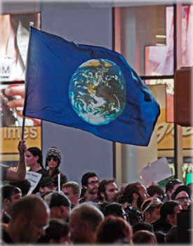 The Earth Day flag made an appearance at Times Square on Saturday night, a reminder that we live on one world. Photo by Eric Francis.