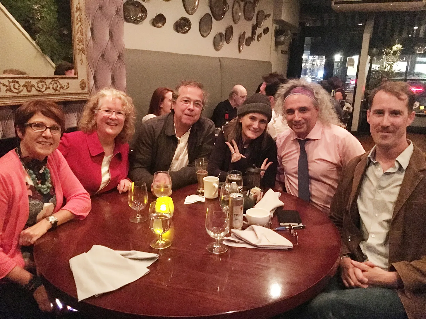Eric McLuhan, Amy Goodman, Eric Francis, and Pacifica Radio & KPFA-Berkeley supporters at a restaurant table in New York.
