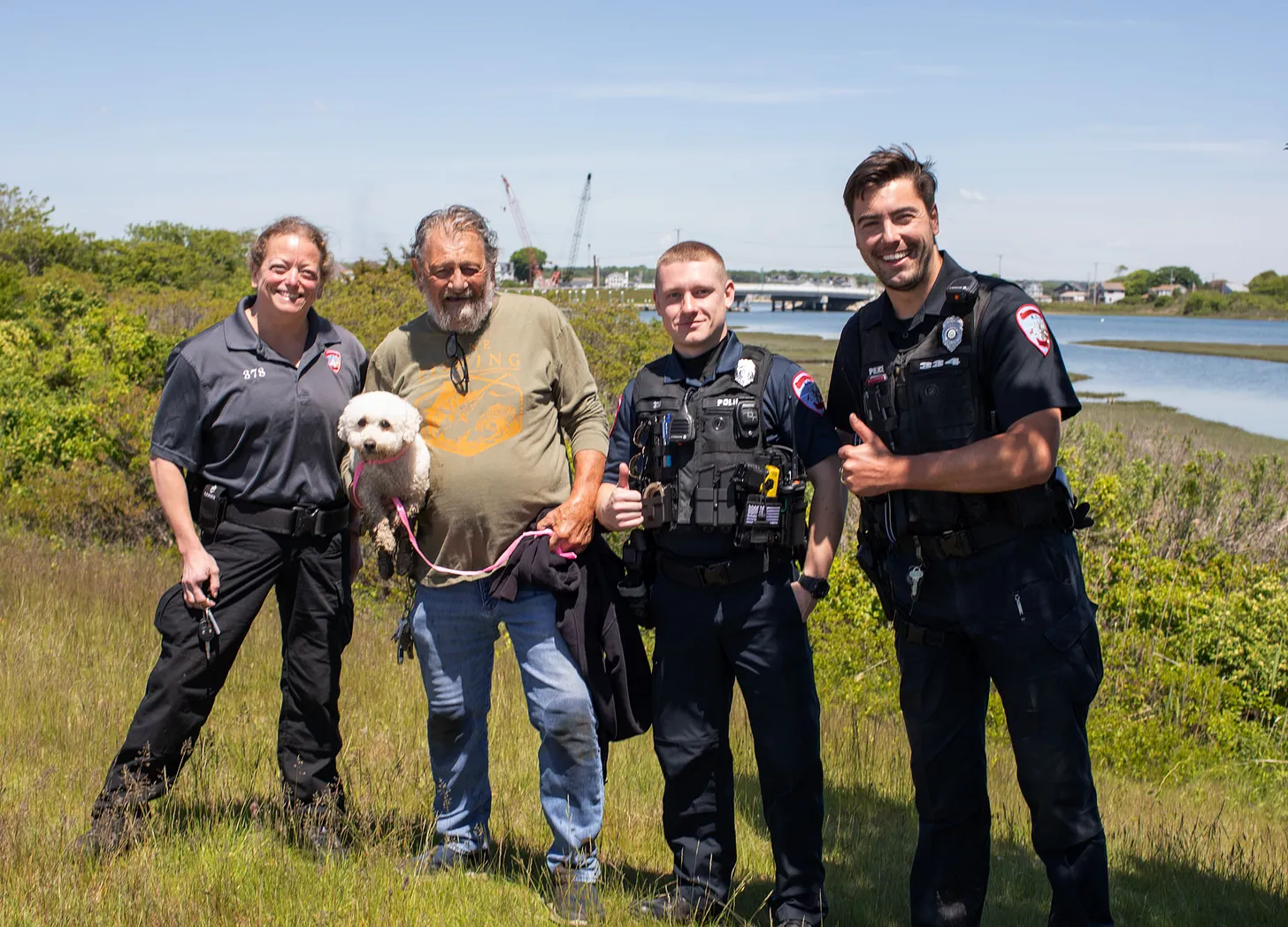 Hollie the do pictured with her rescuers and owner.